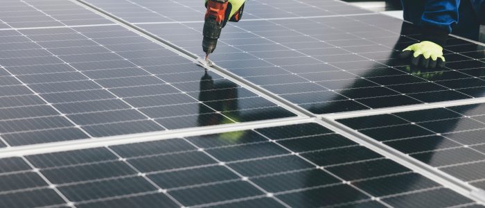 a person using an impact driver installing solar PV