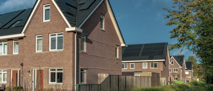 a row of houses with solar panels and batteries UK New Build Estate Scotland